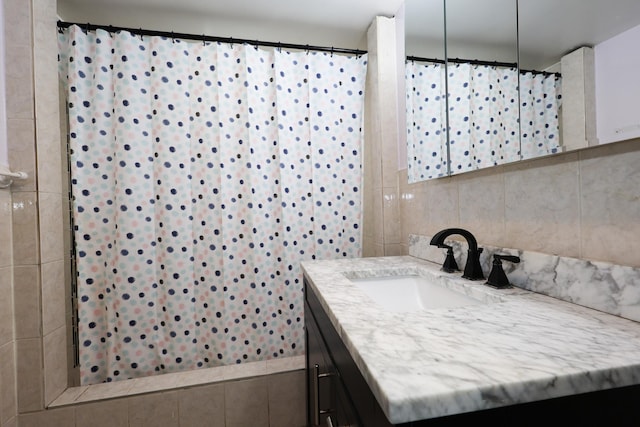 bathroom featuring a shower with shower curtain, tile patterned flooring, tile walls, and vanity