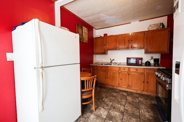 kitchen with black range with gas stovetop, sink, white fridge, and ornamental molding