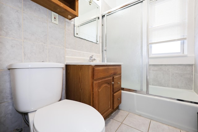 full bathroom featuring enclosed tub / shower combo, tile patterned floors, vanity, tile walls, and toilet