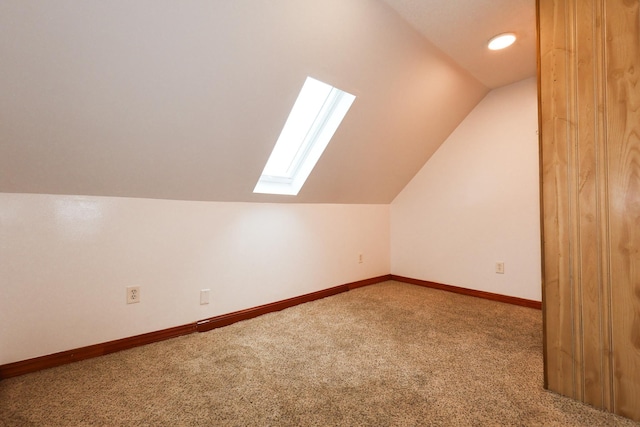 additional living space with carpet and vaulted ceiling with skylight