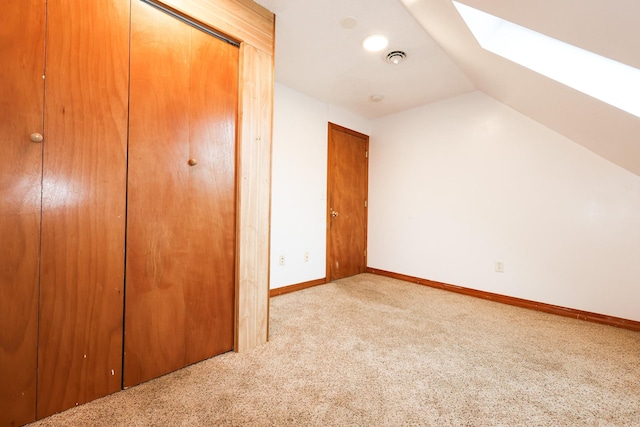 bonus room with light colored carpet and lofted ceiling with skylight