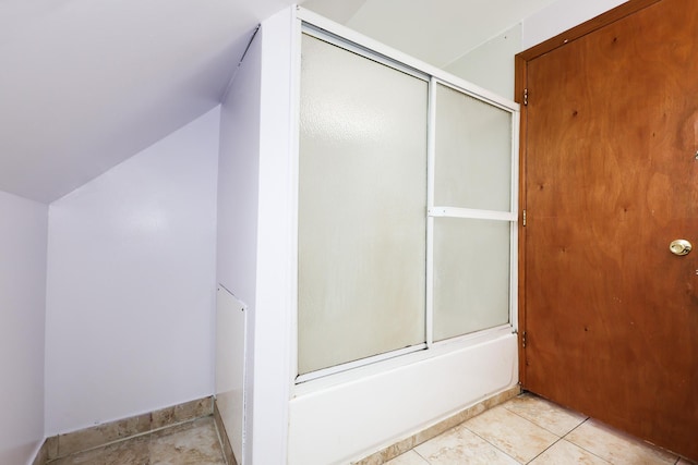 bathroom with lofted ceiling, tile patterned flooring, and shower / bath combination with glass door