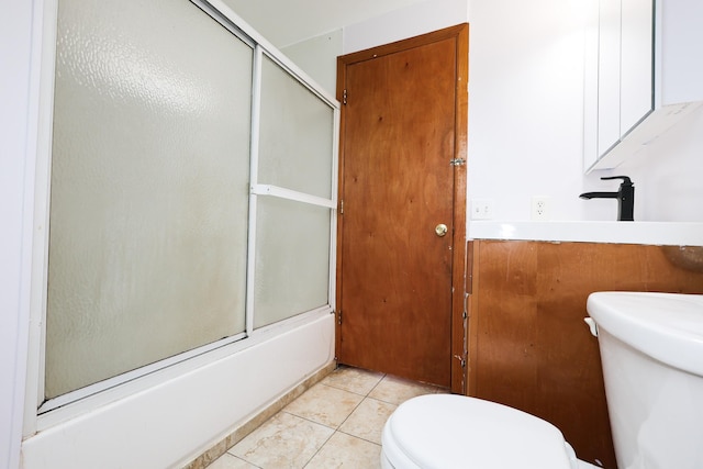 bathroom with toilet, enclosed tub / shower combo, and tile patterned flooring