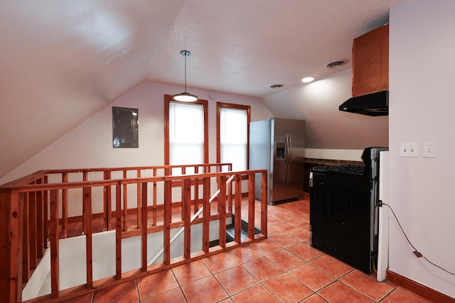 interior space with vaulted ceiling, light tile patterned floors, electric panel, and a textured ceiling