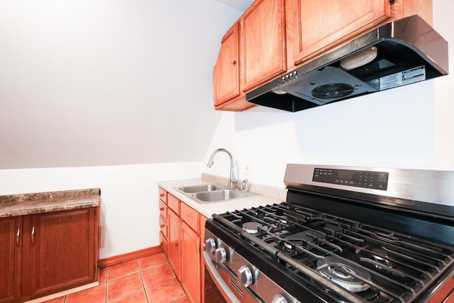 kitchen featuring light tile patterned floors, stainless steel range with gas stovetop, ventilation hood, lofted ceiling, and sink