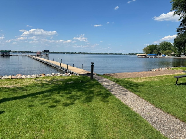 dock area with a water view and a lawn