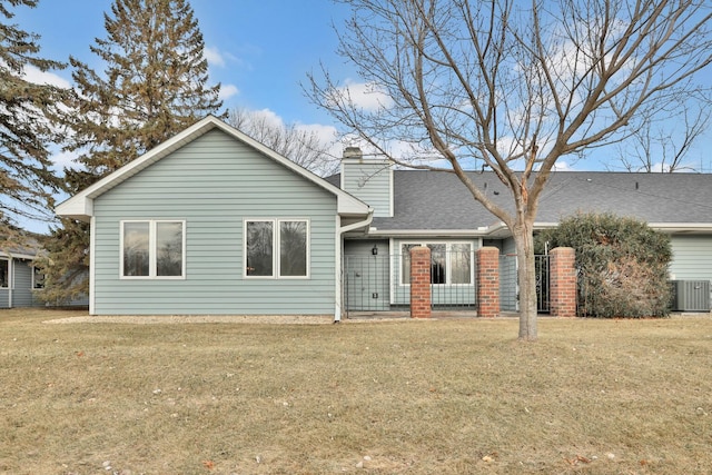 view of front of home with a front lawn and central AC