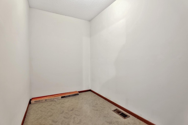 unfurnished room featuring carpet floors and a textured ceiling