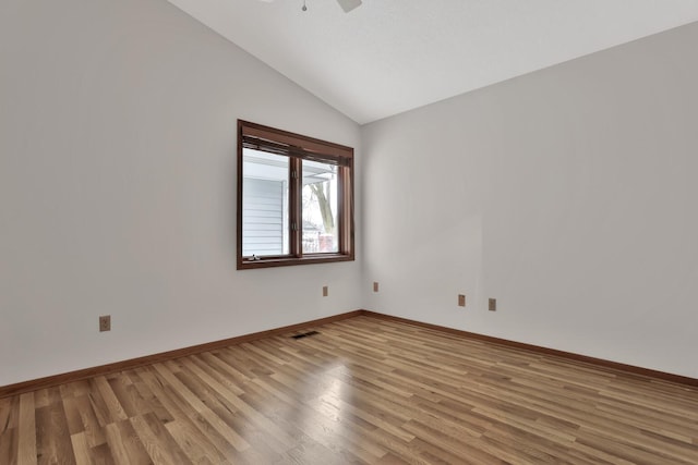 spare room featuring vaulted ceiling and wood-type flooring