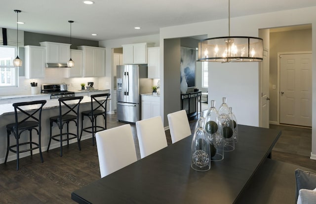 dining room with dark hardwood / wood-style flooring, a chandelier, and a healthy amount of sunlight