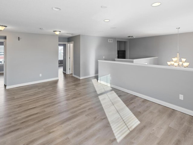 empty room featuring hardwood / wood-style floors and a notable chandelier