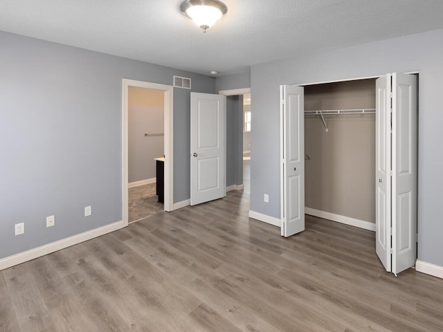 unfurnished bedroom featuring hardwood / wood-style floors and a closet