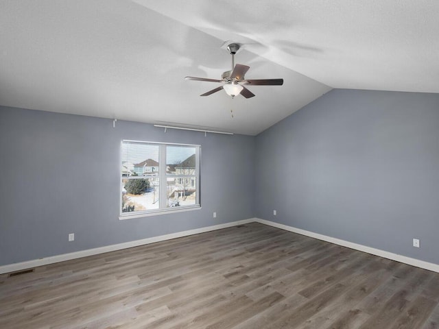 unfurnished room with hardwood / wood-style flooring, vaulted ceiling, and ceiling fan