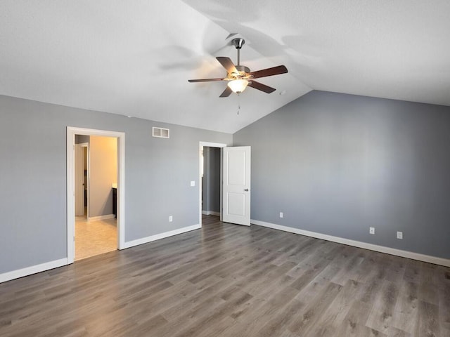 unfurnished bedroom with ensuite bathroom, vaulted ceiling, hardwood / wood-style floors, and ceiling fan