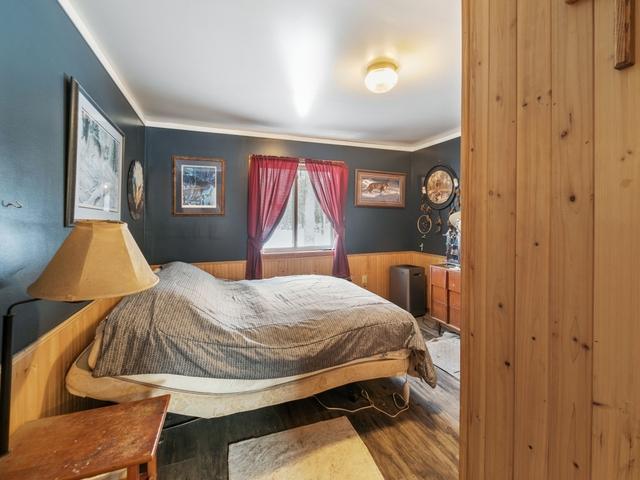 bedroom featuring hardwood / wood-style floors and wooden walls