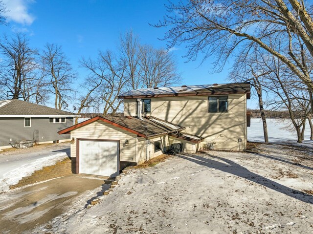 view of snow covered exterior featuring a garage