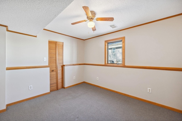 spare room with crown molding, carpet flooring, a textured ceiling, and ceiling fan