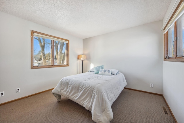 bedroom featuring a textured ceiling and carpet