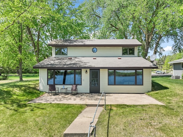 7364 Isaak Ave NW, Annandale, MN 55302 - view of front of house with a front yard, a patio area, cooling unit, and roof with shingles