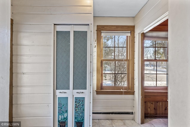 entryway featuring a baseboard radiator and wood walls