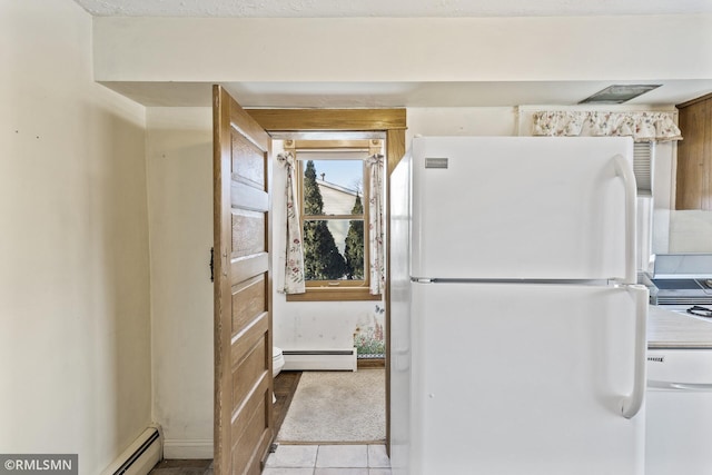 kitchen with baseboard heating, light tile patterned floors, and white fridge