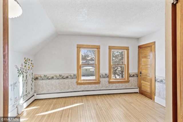 bonus room featuring wood-type flooring, vaulted ceiling, a textured ceiling, and a baseboard radiator