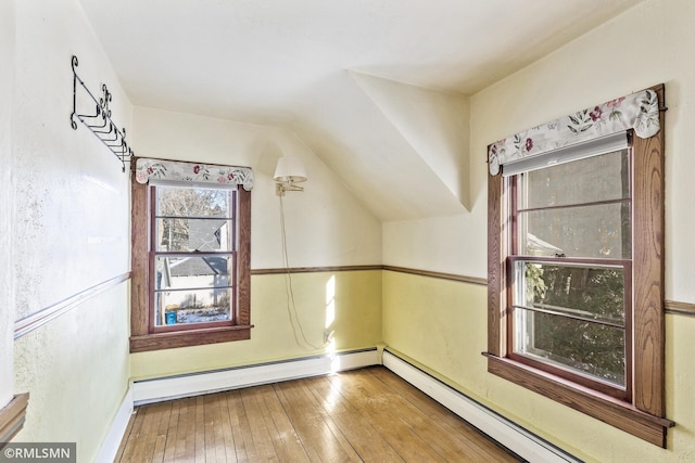 additional living space with hardwood / wood-style flooring and baseboard heating