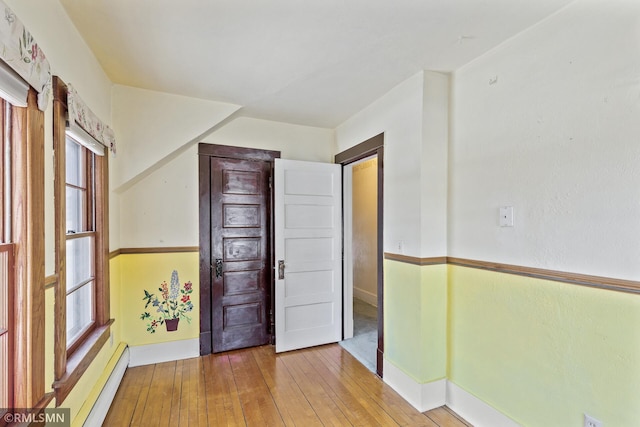 interior space featuring wood-type flooring and a baseboard heating unit