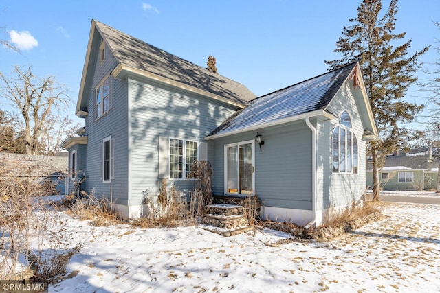 view of snow covered rear of property