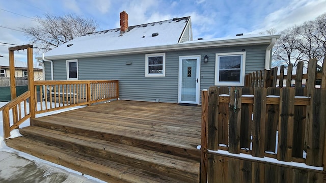 snow covered house featuring a deck