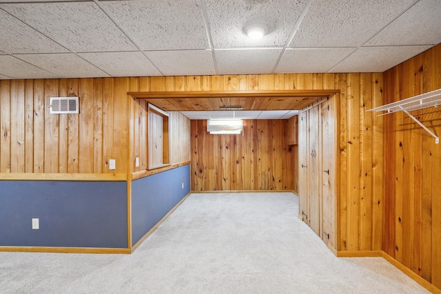 basement with carpet flooring and wood walls