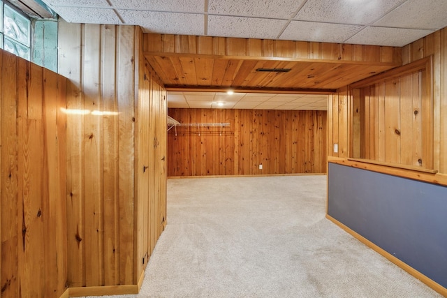 basement with carpet and wooden walls