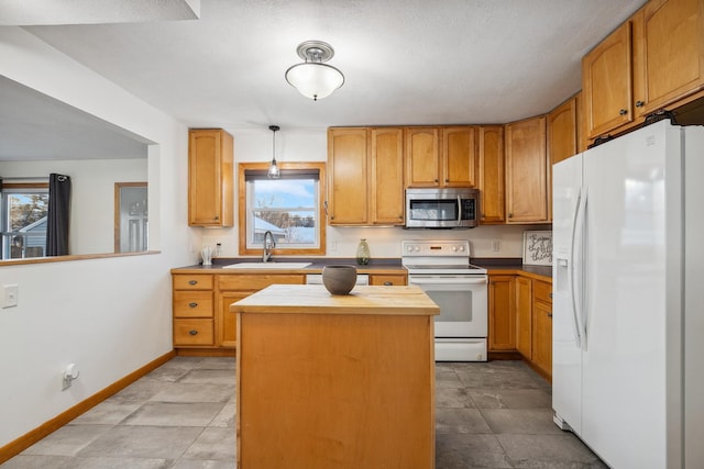 kitchen with a center island, sink, white appliances, and plenty of natural light