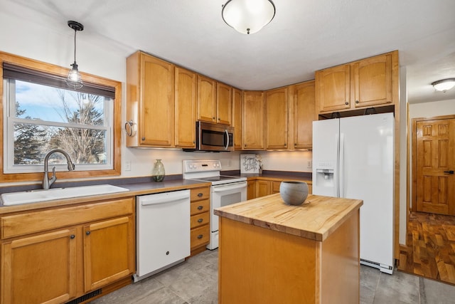 kitchen with pendant lighting, sink, white appliances, wooden counters, and a kitchen island