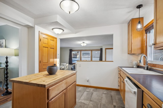 kitchen featuring pendant lighting, sink, butcher block countertops, dishwasher, and a kitchen island