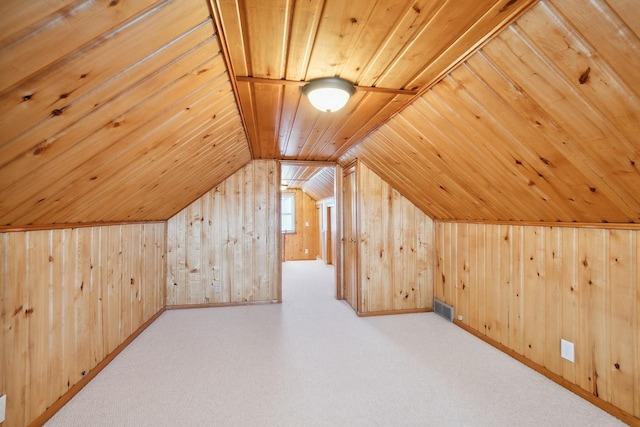 bonus room with vaulted ceiling, light colored carpet, wooden ceiling, and wooden walls