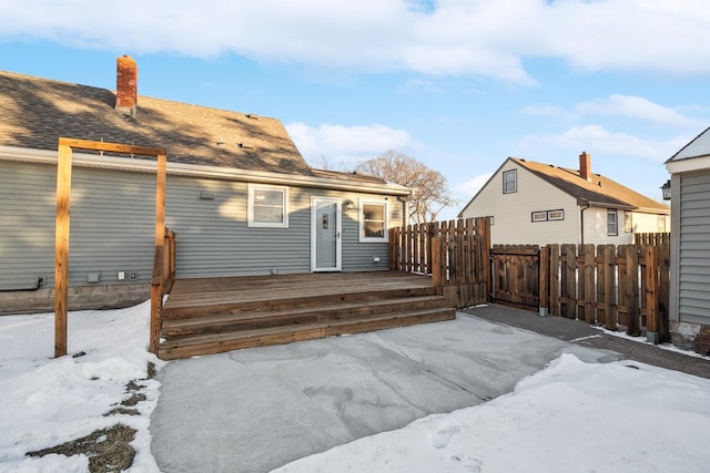 snow covered rear of property featuring a deck