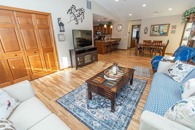 living room featuring vaulted ceiling and light hardwood / wood-style floors