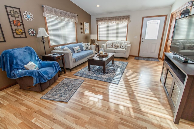 living room with vaulted ceiling and light hardwood / wood-style floors