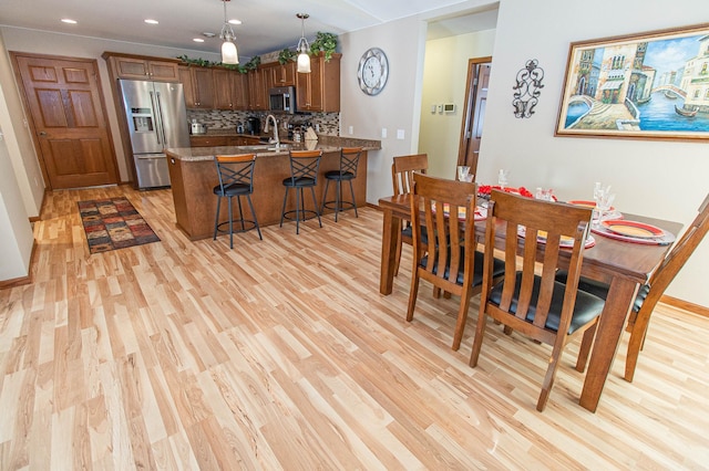 dining area featuring sink and light hardwood / wood-style flooring