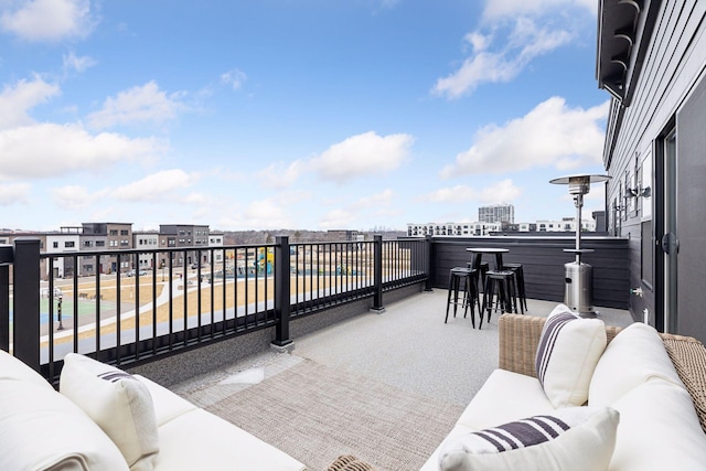 view of patio featuring an outdoor living space, a balcony, and a bar