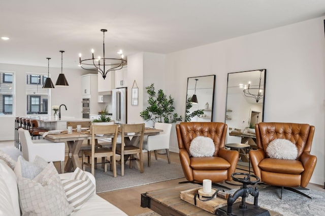 living room featuring sink, light hardwood / wood-style floors, and a chandelier