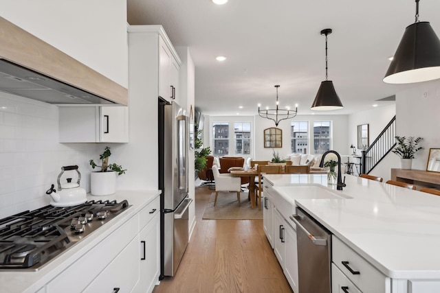 kitchen with sink, stainless steel appliances, an island with sink, white cabinets, and custom exhaust hood