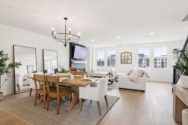 dining room with light hardwood / wood-style floors and a notable chandelier