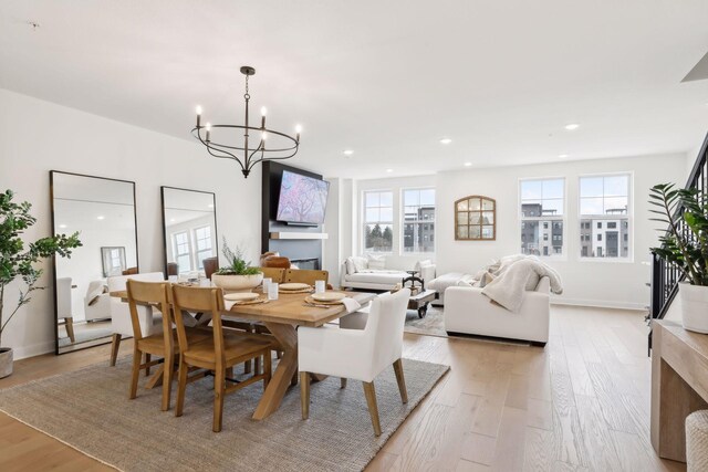 dining space featuring light wood-style flooring, a notable chandelier, and recessed lighting