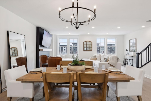 dining room with a chandelier, light wood-type flooring, recessed lighting, and stairs