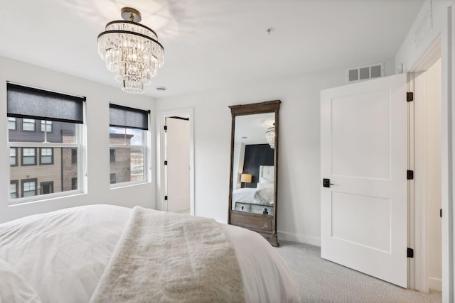 carpeted bedroom featuring baseboards, a notable chandelier, and visible vents