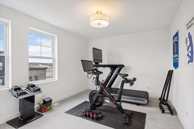exercise room with baseboards and carpet