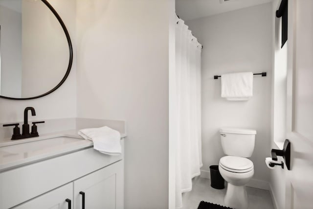full bath with toilet, vanity, and baseboards