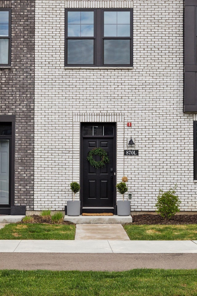 doorway to property with brick siding